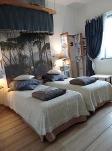 two beds sitting next to each other in a bedroom at Le Château de Roquebère in Condom