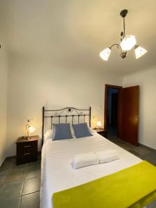 una camera da letto con un grande letto con lenzuola blu e gialle di La Casina del Río · Familiar · Piscina · Gimnasio a Gijón