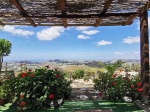 een uitzicht vanaf de veranda van een huis met bloemen bij EverGreen House in Agrigento