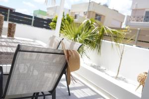 una silla en el balcón con vistas a un edificio en Villa Pastida - Private Pool and Jacuzzi en Pastida