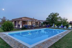 a swimming pool in the yard of a house at Villa Sand Dune in Agios Georgios
