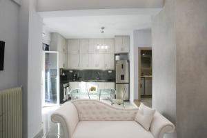 een woonkamer met een witte bank en een keuken bij La casa di San Rocco in Corfu-stad