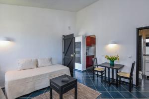 a room with a bed and a table and a kitchen at Pedras D'el Rei in Tavira