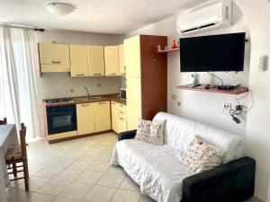 a living room with a white couch and a kitchen at Conti Holiday Homes in Ponza