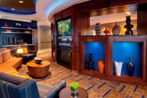 a living room with a couch and a tv at Courtyard by Marriott Madison East in Madison