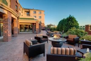 un patio con sillas y mesas y un edificio en Courtyard by Marriott Madison East, en Madison