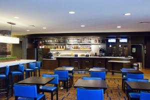 um restaurante com cadeiras e mesas azuis e um bar em Courtyard by Marriott Madison East em Madison