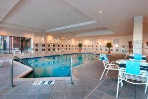 uma piscina com cadeiras e uma mesa num edifício em Courtyard by Marriott Madison East em Madison