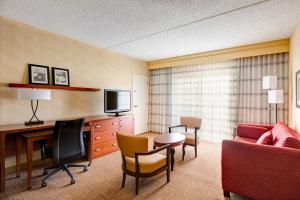 um quarto de hotel com uma secretária e uma sala de estar em Courtyard Manassas Battlefield Park em Manassas