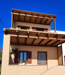 a house with a wooden pergola on it at Kallistis Beach House in Monolithos