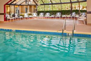 a swimming pool with chairs and a table and some water at Courtyard Manassas Battlefield Park in Manassas