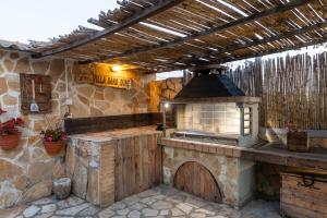 a kitchen with an outdoor kitchen with a stove at Villa Sand Dune in Agios Georgios