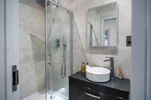 a bathroom with a shower with a sink and a mirror at LiveStay - Modern & Stylish Apartments in Oxfordshire in Didcot