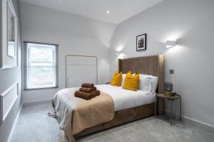 a bedroom with a large bed with yellow pillows at LiveStay - Modern & Stylish Apartments in Oxfordshire in Didcot