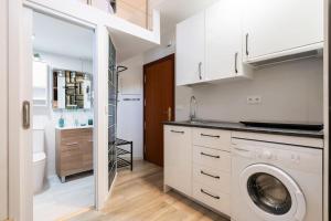 a kitchen with a washing machine in a white kitchen at Beautiful loft for 2 people 25 min from SOL (1) in Madrid