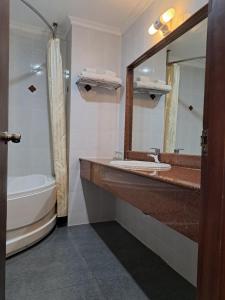 a bathroom with a sink and a tub and a mirror at Liberty 2 Hotel in Ho Chi Minh City