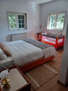 a bedroom with a bed and a table and two windows at Retiro do Prior in Chaves