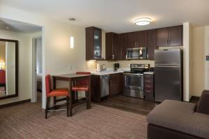 a kitchen with stainless steel appliances and a table with chairs at Residence Inn by Marriott Denver Central Park in Denver