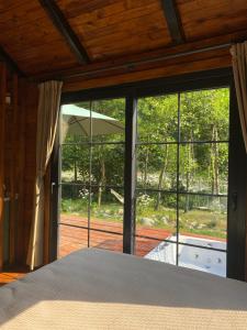 a bedroom with a large glass door to a patio at Noveli Tiny House in Ardeşen