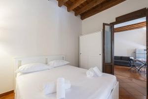 een slaapkamer met een wit bed en een woonkamer bij Youhosty - Ripa5 C in Milaan
