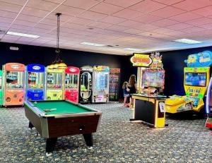 ein Zimmer mit mehreren Arcade-Spielen und einem Billardtisch in der Unterkunft Resort style home across from the clubhouse. in Kissimmee