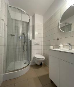 a bathroom with a shower and a toilet and a sink at AMARIT in Dziwnów