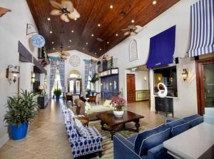 ein großes Wohnzimmer mit blauen Sofas und Tischen in der Unterkunft Resort style home across from the clubhouse. in Kissimmee