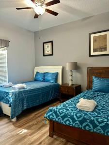 1 Schlafzimmer mit 2 Betten und einem Deckenventilator in der Unterkunft Resort style home across from the clubhouse. in Kissimmee