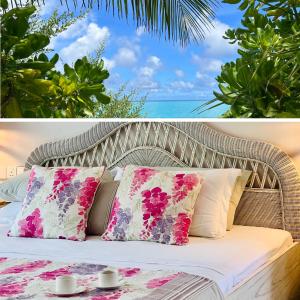 wiklinowe łóżko z poduszkami i stół przed oceanem w obiekcie Fairytale Inn w mieście Thoddoo