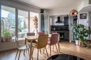 a dining room and living room with a table and chairs at F3 Terrasse La défense in Courbevoie