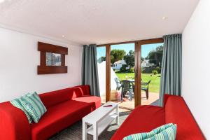 a living room with a red couch and a table at Pedras D'el Rei in Tavira