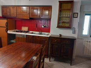 a kitchen with wooden cabinets and a wooden table at LA CASA IN PIAZZA in Capracotta