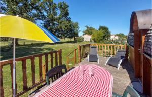 a table and chairs and an umbrella on a deck at Stunning stacaravan In Pouilly-sous-charlieu With Kitchen in Pouilly-sous-Charlieu