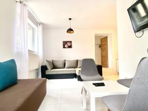 a living room with a couch and a table at Familly Apartament 2 in Międzyzdroje +4 photos
