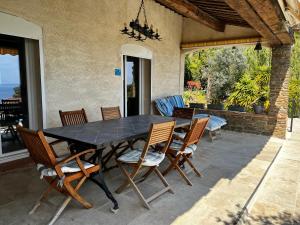 a black table and chairs on a patio at La Villa Pavilou in Le Lavandou