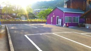 un estacionamiento frente a un edificio púrpura en Yado Seven Beach, en Naoshima