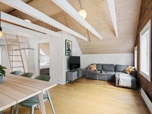 スタヴァンゲルにあるCharming Rooftop Apartment In Heart Of Stavangerのリビングルーム(ソファ、テーブル付)