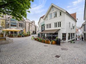 a cobblestone street in a city with a white building at Charming Rooftop Apartment In Heart Of Stavanger in Stavanger