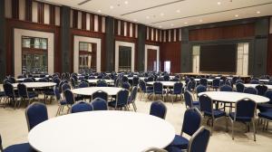 a conference room with tables and chairs and a screen at Al-Burhan Hotel in Baghdad