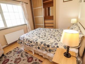 a bedroom with a bed and a lamp on a table at Gap of Dunloe in Derrylea