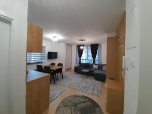 a kitchen and living room with a couch and a table at Apartment Bjelasnica DAH in Bjelašnica