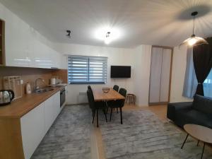 a kitchen and living room with a table and a couch at Apartment Bjelasnica DAH in Bjelašnica +6 photos