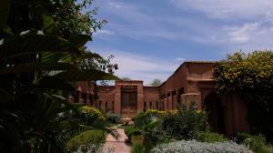 un ancien bâtiment avec une cour ornée de fleurs et de plantes dans l'établissement Asnouss, à Marrakech