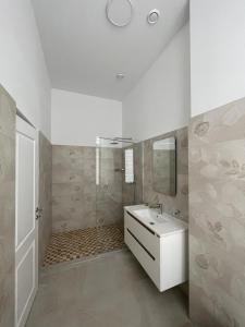 a white bathroom with a sink and a shower at Resedinta Cina in Braşov