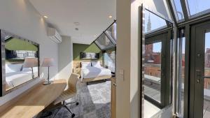 a room with two beds and a desk with a desk at Hampton By Hilton Gdansk Old Town in Gdańsk