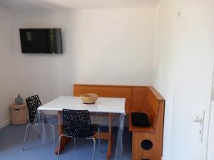 a room with a table and chairs and a tv at La Campana 104 in Bielle