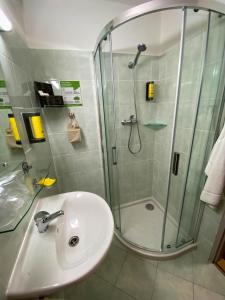 a bathroom with a glass shower and a sink at STEELHOUSE Hotel in Třinec