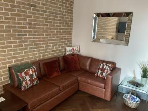 a brown couch in a room with a brick wall at Queens View in London