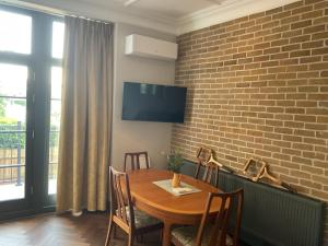 a dining room with a wooden table and a brick wall at Queens View in London