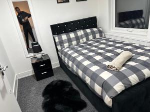 een man die een foto neemt van een slaapkamer met een bed bij 3 bedroom house with garden in Tottenham london in Londen